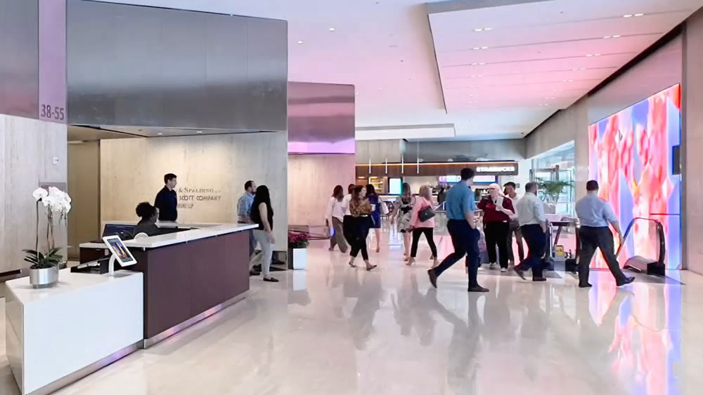 A busy office building inside lobby, with InforCenter station at the Security Desk